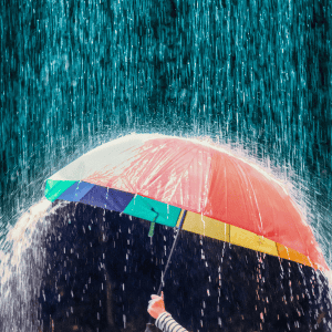 Rainy umbrella in stormy weather with heavy rainfall and dark clouds.