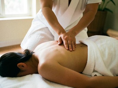 Thai massage therapist applying acupressure along the back