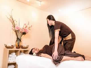 Woman receiving traditional Thai massage in Glasgow spa setting.
