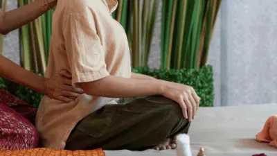 Practitioner performing traditional Thai massage stretches on a client in Glasgow.