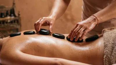 Therapist applying hot stones during a relaxing massage in Glasgow.