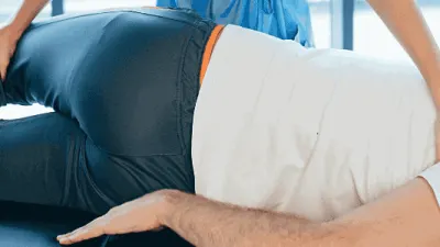 Massage therapy easing sciatica nerve pain in the lower back and leg.